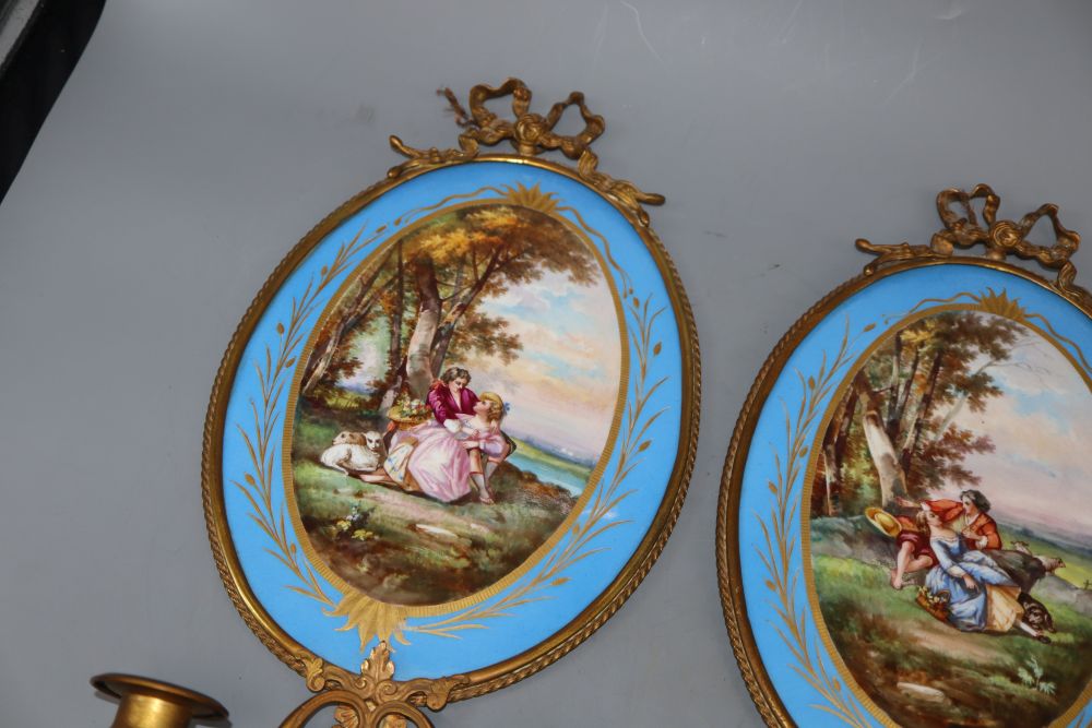 A pair of gilt brass two branch wall sconces with oval Sevres style plaques, length 40cm